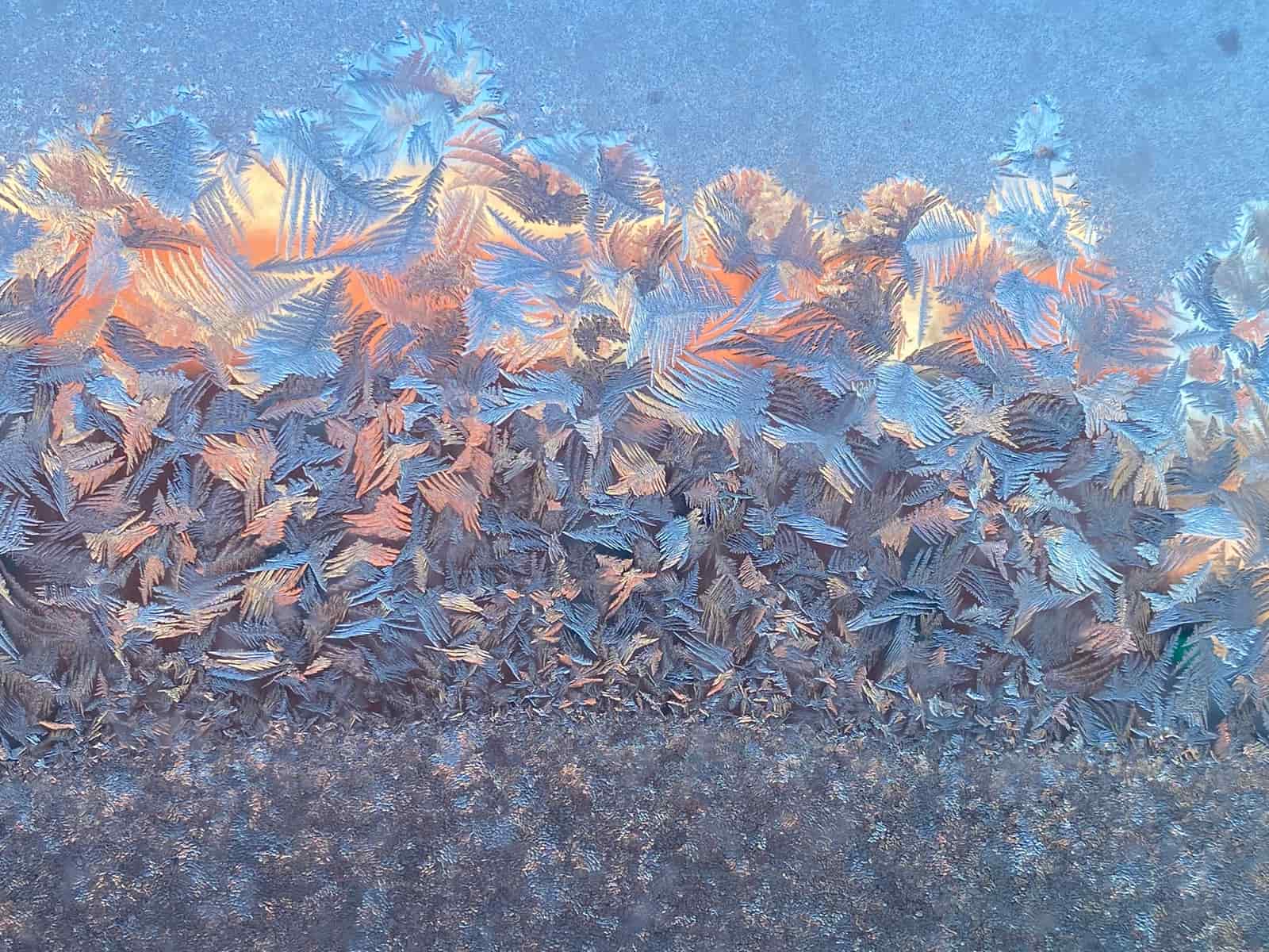 A frost-edged window pane in a warm room on a cold morning